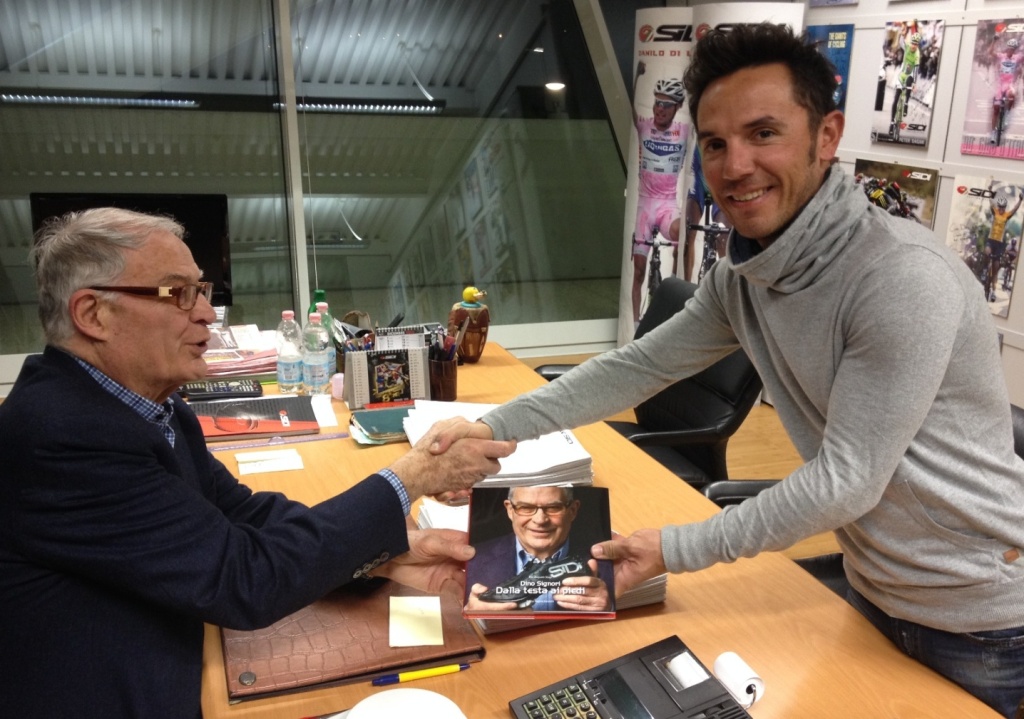 click to enlarge Dino Signori mentre consegna a Purito Rodriguez il libro “Dalla Testa ai Piedi”